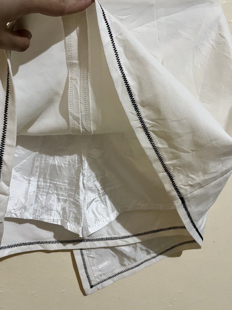 White wrap skort with black contrast stitching size L (Category: Skirts) located in Manila. Submitted by lovedbynixe (Listing ID 1470270077, Image 3). Description: White elegant skirt ₱200 Size 27-28 Loc pampanga Mop gcash/gotyme - Color: Clean solid white with striking black contrast stitching - Style: Wrap-style skort with an asymmetric hem and fake front pocket detail - Comfort: Built-in shorts underneath for worry-free movement - Closure: Con