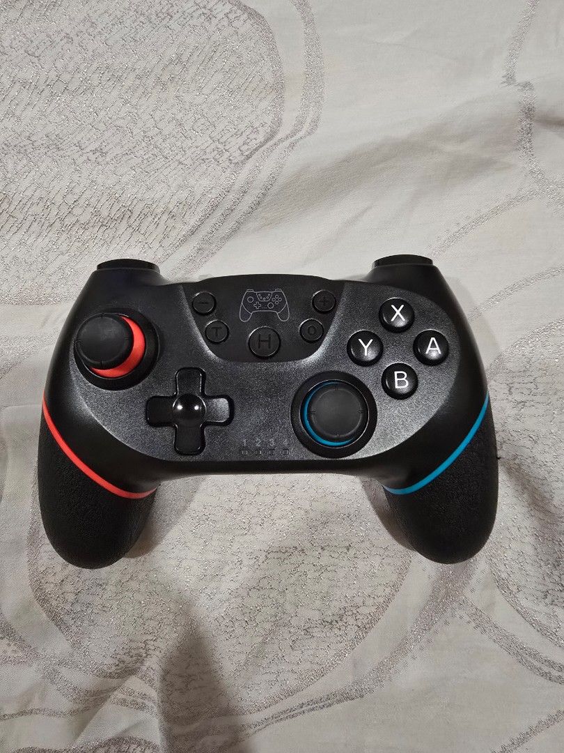 Wireless Controller (Category: Controllers) located in Klang. Submitted by press_startgame (Listing ID 1470189612, Image 1). Description: - Color: Black with neon blue and red grips - Compatibility: pc and android phone - Layout: Standard ABXY, dual analog sticks, D-pad, and extra center buttons - Comfort: Textured handles for better grip during long gaming sessions - Power: 5V 550mA input, easy to connect and play.
