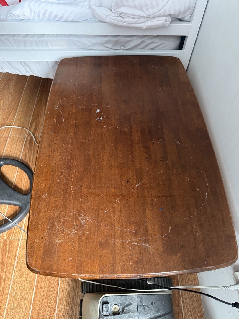 Wooden Coffee Table with Lower Shelf (Category: Tables & Sets) located in Quezon City. Submitted by vns31181225 (Listing ID 1470314544, Image 2). Description: - Solid wood coffee table with a warm brown finish - Features a convenient slatted bottom shelf for extra storage - Sturdy four-leg design with safe rounded corners on the top - Surface shows visible scratches, scuffs, and wear from daily use - Condition: Pre-loved, ready for pickup.