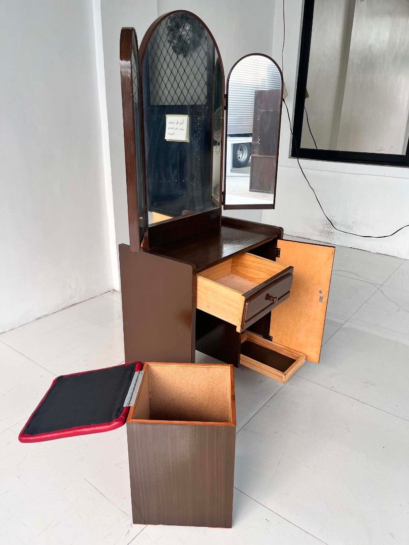 Wooden Vanity Dressing Table with Tri-Fold Mirror and Stool (Category: Tables & Sets) located in Manila. Submitted by roveeeeelen_06 (Listing ID 1470169910, Image 2). Description: - Brown wooden vanity set with a smooth polished finish - Large adjustable tri-fold mirror setup - Includes a matching stool with a comfortable red cushioned top - Ample storage: pull-out drawer on the left and a shelved cabinet on the right - Sturdy structure with clea
