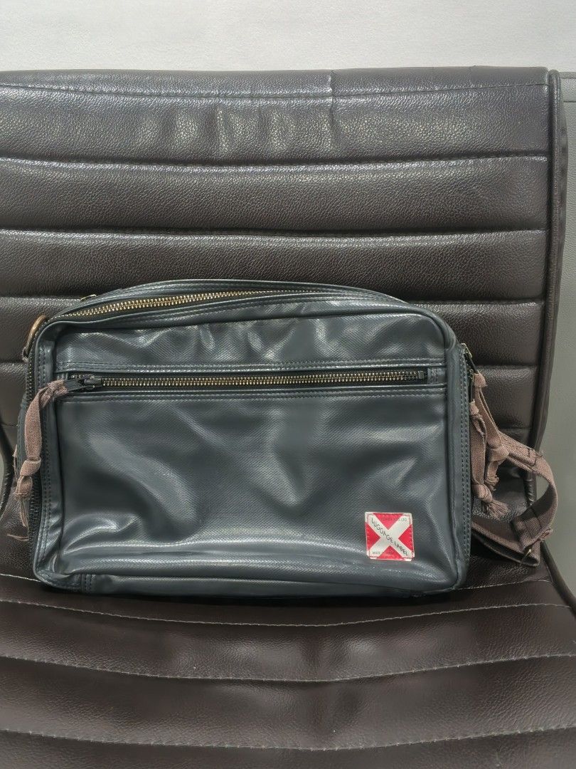 Yoshida & Co (Porter) (Category: Sling Bags) located in Kabacan. Submitted by thriftedsupremacy11 (Listing ID 1470348082, Image 1). Description: The bag is crafted from a distinctive rayon canvas with a PVC coating, giving it a signature glossy finish and a rugged, military-inspired look. It also features the iconic red-and-white cross logo patch in the corner and expandable zipper gussets..