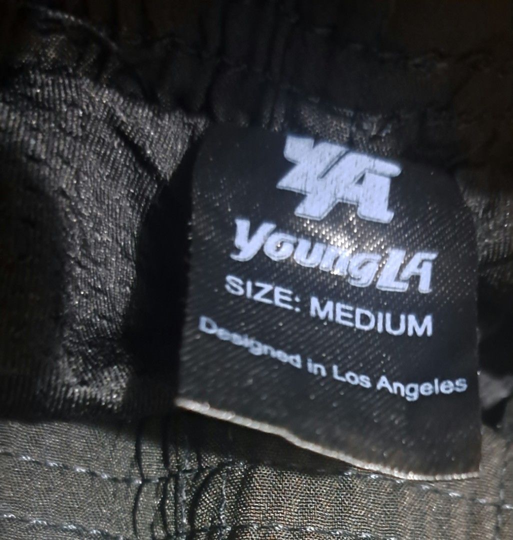 YoungLA Black Gym Shorts Size Medium (Category: Shorts) located in San Fernando, Camarines Sur. Submitted by ladderaya (Listing ID 1470243691, Image 2). Description: - Brand: YoungLA - Color: Black - Size: Medium (Waist: 30-32 inches, Length: 14.5 inches) - Features: Elastic waistband with drawstrings, small reflective logo near the hem - Condition: Normal signs of usage (bawal sa maselan) - Perfect for gym workouts and casual wear - PM for inqui