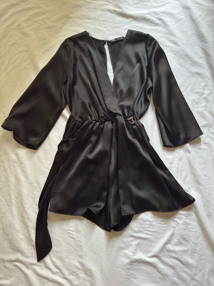 Zara Black Satin Romper Size XS (Category: Rompers) located in Cebu City. Submitted by _t.rix (Listing ID 1470187466, Image 2). Description: - Brand: Zara - Style: Black satin romper with V-neck crossover front - Size: XS (EUR XS, USA XS, MEX 24) - Features: Flare sleeves, attached waist tie with side loop, back button closure with keyhole cutout - Material: Smooth, shiny fabric - Condition: Clean and ready to wear.