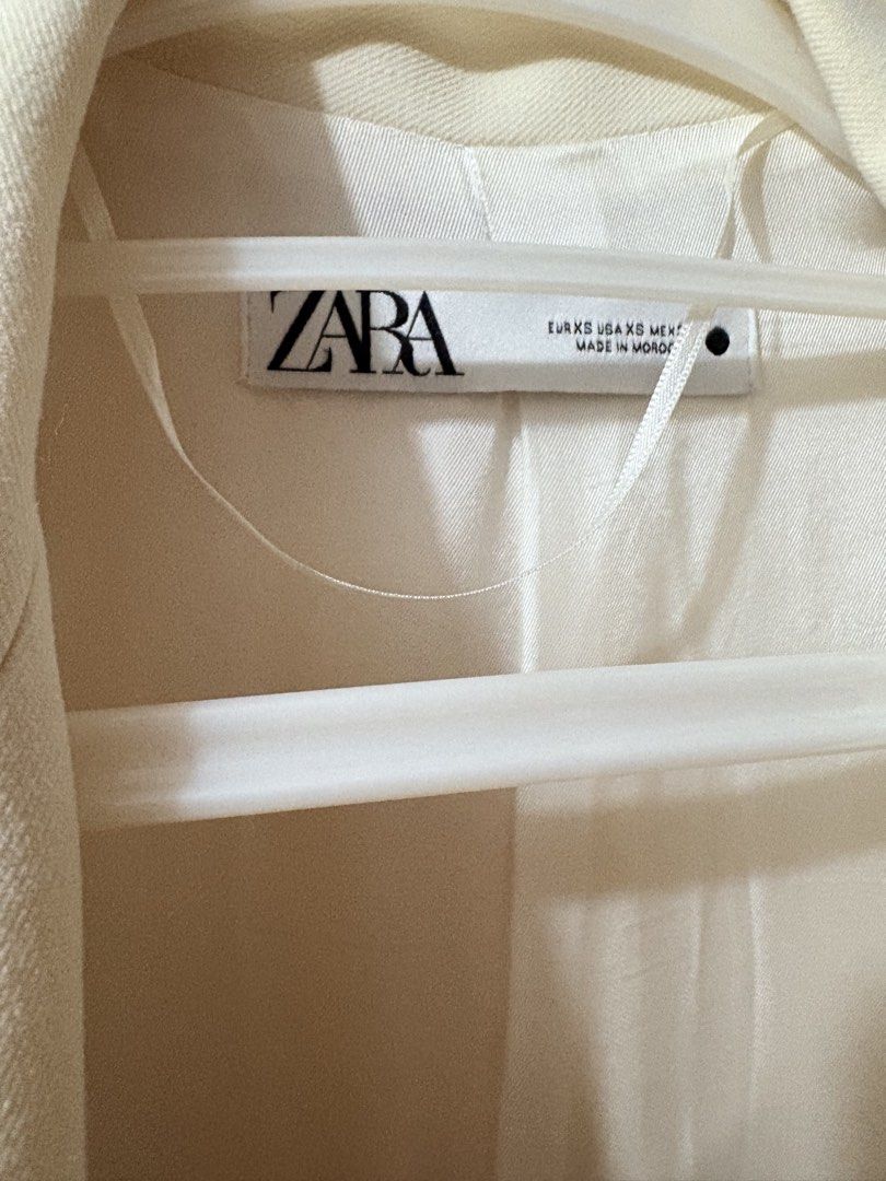 Zara Double Breasted Blazer White XS (Category: Coats, Jackets and Outerwear) located in Munoz. Submitted by Liiz27 (Listing ID 1470168021, Image 2). Description: - Brand/Model: Zara double breasted blazer - Size: EUR XS / USA XS - Color: White - Fit & Style: Tailored fit with structured shoulders, lapel collar, and matching white buttons - Features: Front flap pockets, button cuffs, and a fully lined interior - Versatility: Clean minimalist look