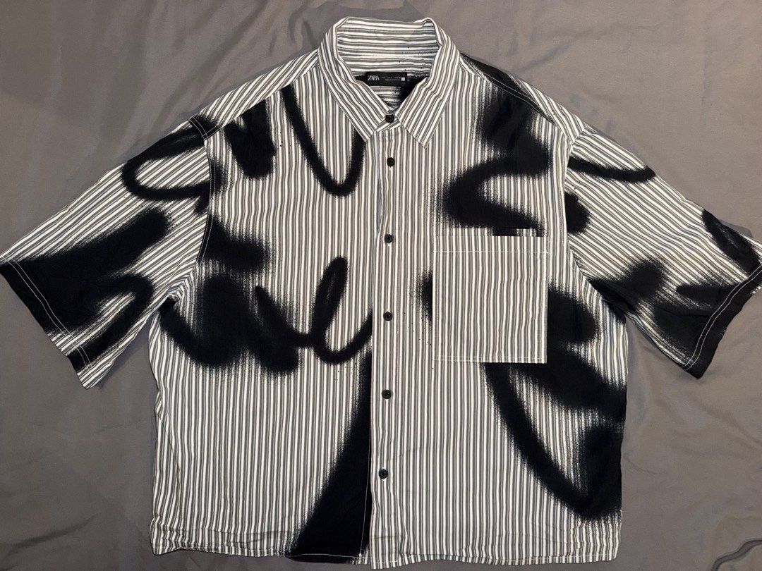 Zara Short Sleeve Shirt (Category: Tshirts & Polo Shirts ) located in Taguig. Submitted by j.lax. (Listing ID 1470330783, Image 1). Description: - Brand: Zara - Size: L - Color: Black and white vertical stripes with bold spray paint graffiti print.