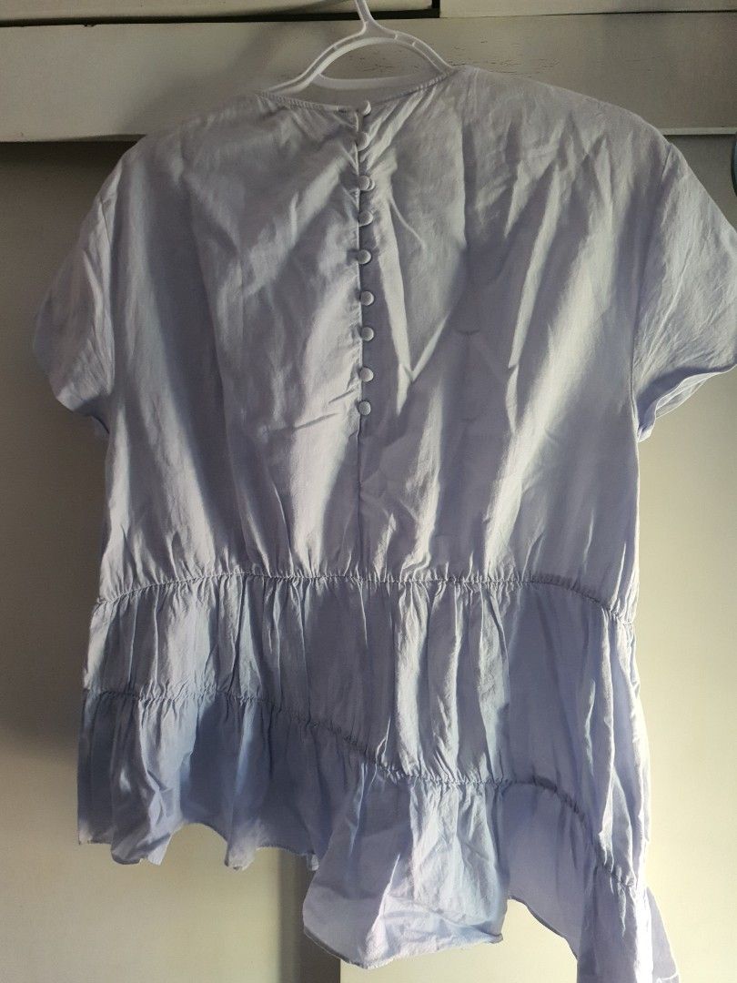Zara Trafaluc Collection Light Blue Ruffled Blouse Size S (Category: Blouses) located in Paranaque City. Submitted by love_opaque (Listing ID 1470224280, Image 3). Description: - Brand: Zara Trafaluc - Size: EUR S / USA S / MEX 26 (Relaxed fit) - Color: Light Blue - Material/Design: Textured fabric with horizontal smocked ruffling on midsection and lower tier - Neckline: Round neck with cute fabric-covered button-down back closure - Condition: Ex