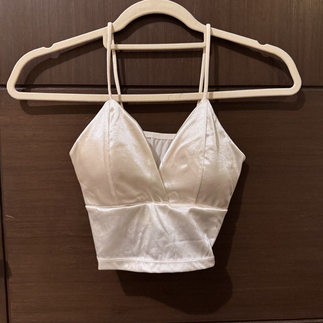 White Satin Crop Top Cami (Category: Sleeveless) located in Quezon City. Submitted by ianne.declutter (Listing ID 1470176731, Image 1). Description: - Brand: Zara TRF - Style: V-neck crop top with thin shoulder straps and criss-cross back - Material: White satin, shiny and smooth texture - Styling tip: Looks amazing paired with a denim jacket - Condition: Excellent.
