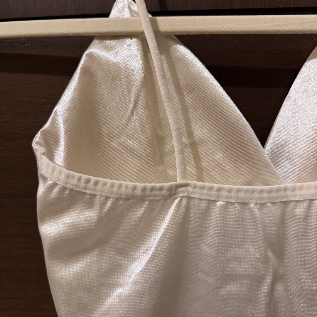 White Satin Crop Top Cami (Category: Sleeveless) located in Quezon City. Submitted by ianne.declutter (Listing ID 1470176731, Image 3). Description: - Brand: Zara TRF - Style: V-neck crop top with thin shoulder straps and criss-cross back - Material: White satin, shiny and smooth texture - Styling tip: Looks amazing paired with a denim jacket - Condition: Excellent.