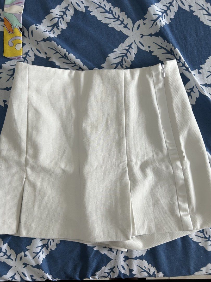 Zara white skorts (Category: Skirts) located in Manila. Submitted by isabelle_1104 (Listing ID 1470277331, Image 1). Description: - Color: Crisp white - Style: Mini skirt with trendy front pleat details - Closure: Convenient side zipper - Fit: Structured fabric that holds its shape nicely - Design: Clean hem and minimal look - Versatility: Great basic piece for mixing and matching with different tops.