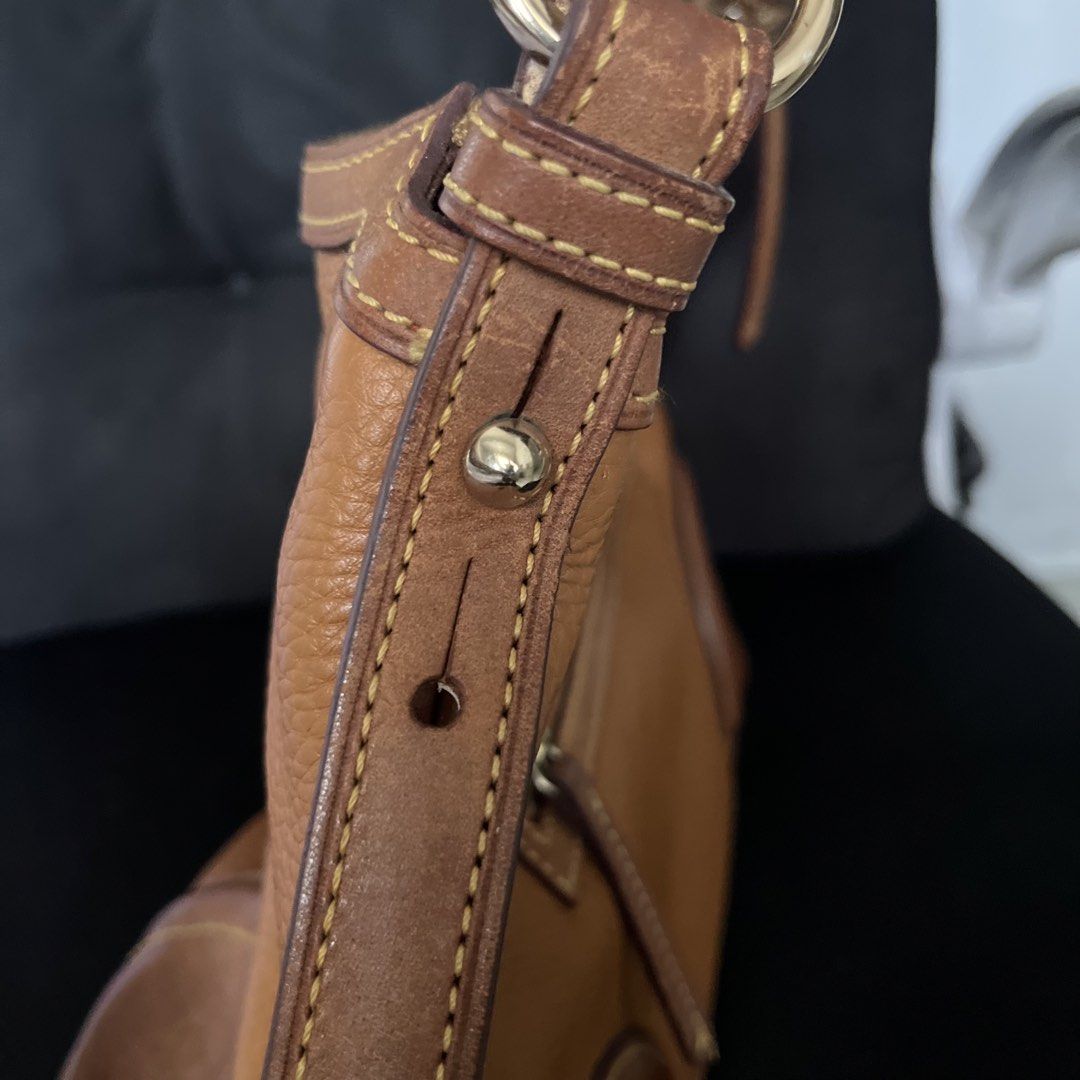 🇺🇸 Dooney & Bourke Brown Leather Shoulder Bag (Category: Luxury Bags & Wallets) located in Manila. Submitted by prelovedpick.com (Listing ID 1470402144, Image 3). Description: - Material: Brown pebble leather with darker leather trim and contrast stitching - Hardware: Silver-tone with front metal logo plate - Pockets: Exterior zipper pocket on the back, interior fabric lining with leather patch branding - Strap: Adjustable shoulder strap with b