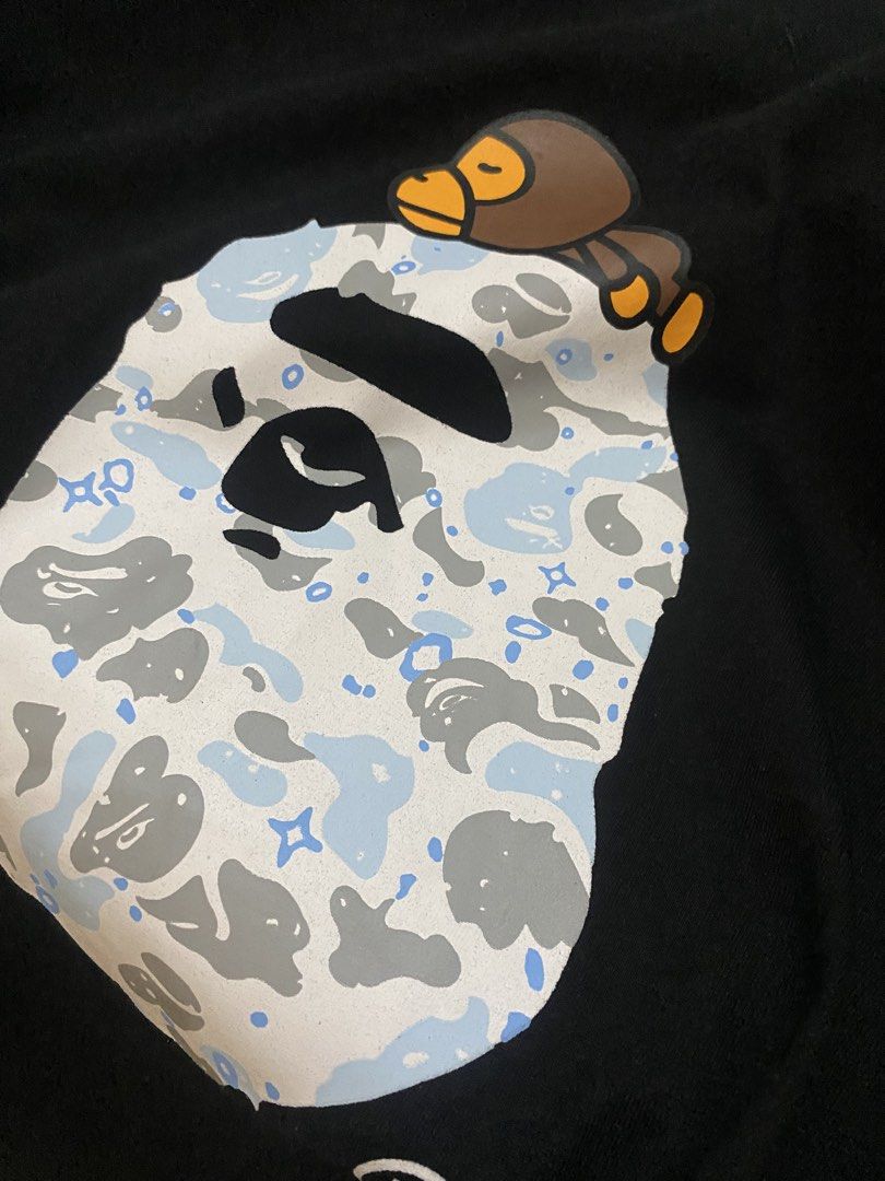 A Bathing Ape Long Sleeve (Category: Hoodies) located in Marikina City. Submitted by ctgccc (Listing ID 1470485559, Image 3). Description: Black long sleeve Size: medium. Used: twice Damages: none Loc: Marikina Large Baby Milo and camo graphic printed right on the front. Neck tape has embossed lettering detail..
