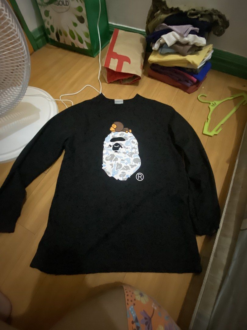 A Bathing Ape Long Sleeve (Category: Hoodies) located in Marikina City. Submitted by ctgccc (Listing ID 1470485559, Image 2). Description: Black long sleeve Size: medium. Used: twice Damages: none Loc: Marikina Large Baby Milo and camo graphic printed right on the front. Neck tape has embossed lettering detail..