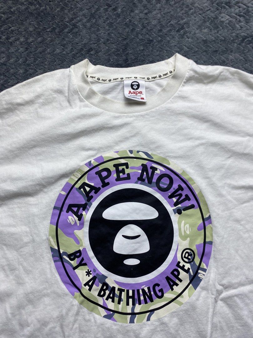 Aape By A Bathing Ape Long Sleeve Tee (Category: Tshirts & Polo Shirts ) located in Olongapo. Submitted by WAVYT (Listing ID 1470552412, Image 2). Description: White long sleeve shirt from Aape by A Bathing Ape. Big circular logo graphic on the chest with purple and green camo print inside. Classic Ape head right in the center. Neck tag inside and sleeve patch logo detail included. Size large printed on the inner collar label. Streetwear piece, c