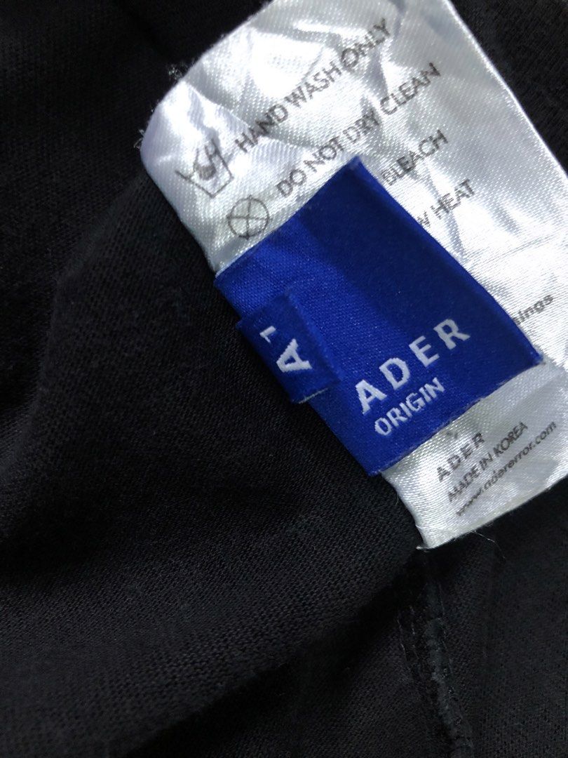 Ader Error Origin Blue Logo T-Shirt (Category: Tshirts & Polo Shirts ) located in Manila. Submitted by purewater.2554df (Listing ID 1470499583, Image 2). Description: Black short-sleeve tee from Ader Error Origin. Small blue overlapping logo graphic on the chest. Size A1 tag inside. Made in Korea. Hand wash only care label attached. Clean solid black cotton fabric, relaxed fit..