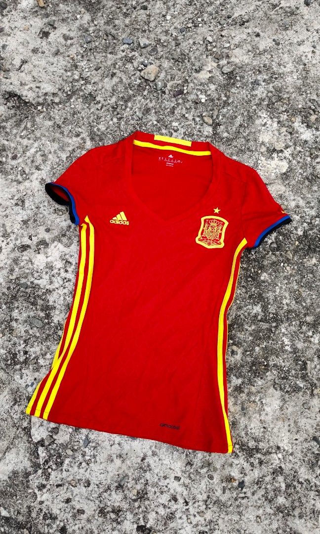 Adidas 2016 Spain Home Jersey (Category: Blouses) located in Mati. Submitted by gsthrift (Listing ID 1470361557, Image 2). Description: This piece is an official Adidas women's home jersey produced for the Spanish national football team's UEFA Euro 2016 campaign. Constructed with Adidas Climacool technology, it features the team's traditional red and yellow palette with subtle triangular jacquard patterns woven into the fabric. The front displays