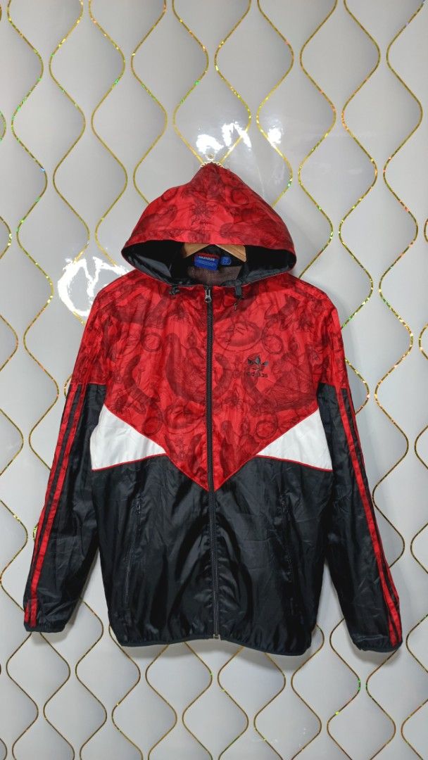 Adidas Red Black White Graphic Windbreaker Jacket (Category: Coats, Jackets and Outerwear) located in Manila. Submitted by zariyah.1986 (Listing ID 1470454805, Image 1). Description: - Brand: Adidas - Style: Hooded windbreaker jacket with full zip closure - Colorway: Red, black, and white with a unique graphic pattern on the top and hood - Details: Red three-stripe branding on sleeves and embroidered trefoil logo on the chest - Lining: Breathable