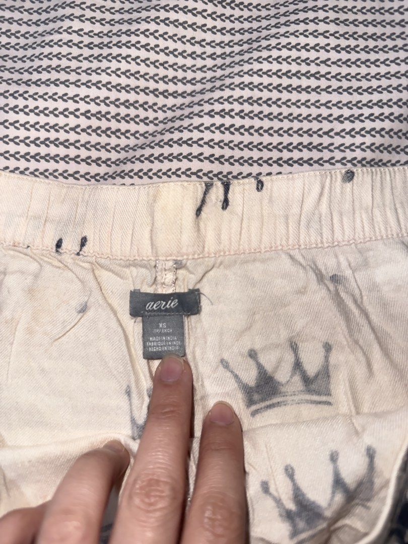 Aerie Crown Print Sleep Shorts (Category: Shorts) located in Santa Ana. Submitted by fatikilla (Listing ID 1470364977, Image 2). Description: - Brand: Aerie - Size: XS - Color/Design: Cream with grey crown print - Details: Dark blue lace trim on hems and matching dark blue satin ribbon drawstring waist - Material/Origin: Made in India, soft and breathable fabric - Condition: Perfect for sleeping, lounging, and relaxing at home.