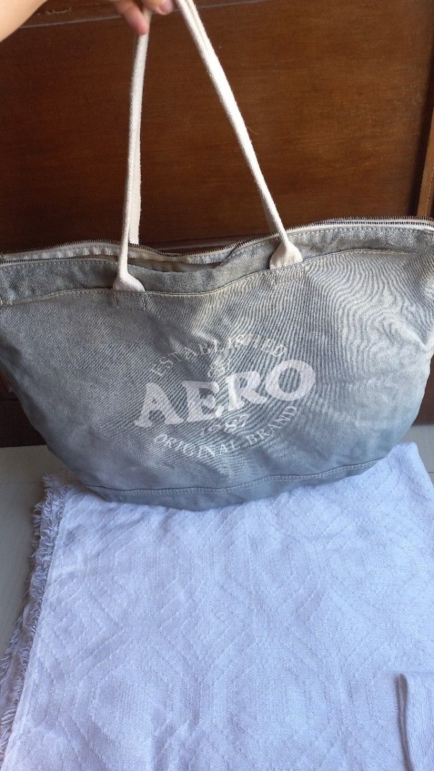 Aero Canvas Tote Bag Grey Large (Category: Tote Bags) located in Rizal. Submitted by mayra74 (Listing ID 1470357614, Image 3). Description: - Brand: Aero - Material: Grey canvas with fully lined off-white interior - Design: Big front graphic print with established branding and white fabric handles - Closure: Secure zip top - Capacity: Spacious main compartment ideal for daily essentials, groceries, or travel.