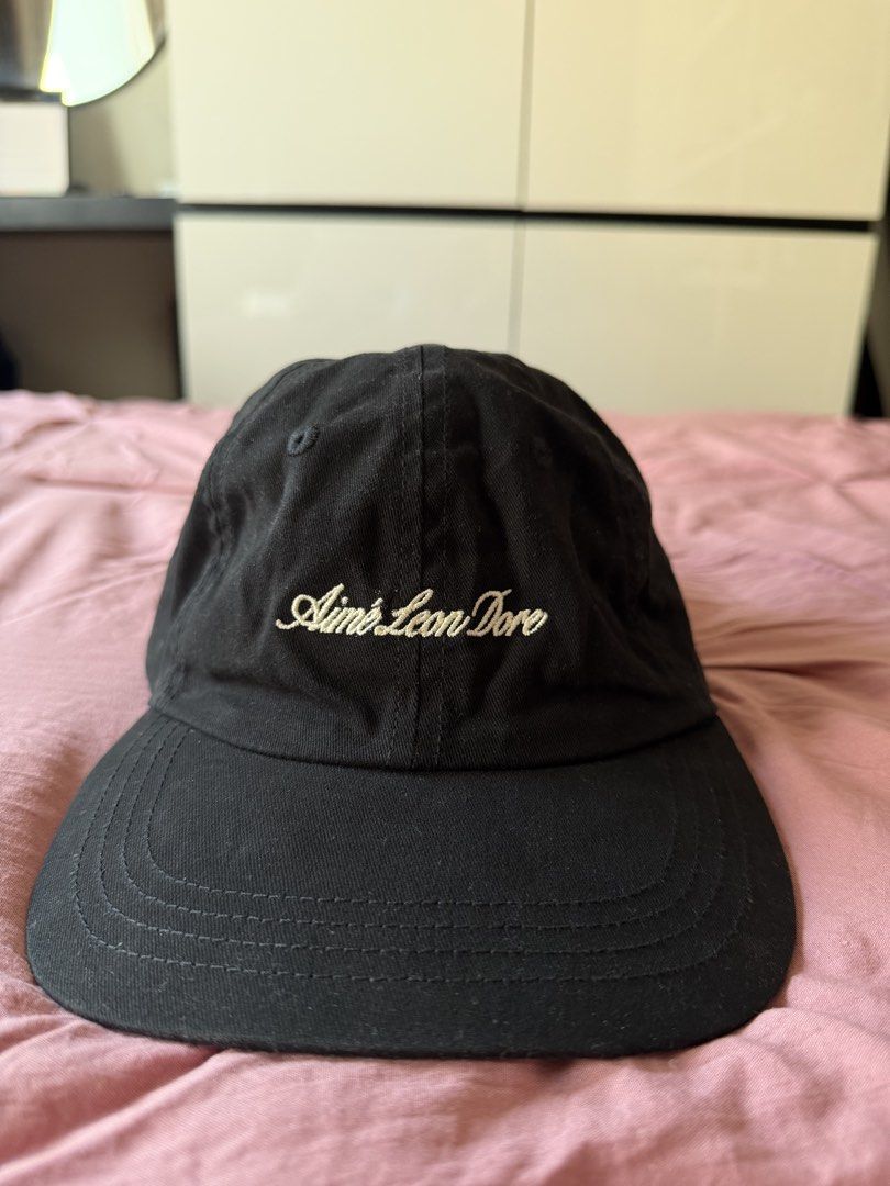aimé leon dore script logo cap black (Category: Caps & Hats) located in Manila. Submitted by _____car0usell (Listing ID 1470391189, Image 2). Description: - used only once (3.5k from ig shop) - classic black with cream script logo embroidery - adjustable strap closure with metal hardware - clean interior woven brand tag at back seam - with minor sweatband stain from wearing once, can easily be washed.