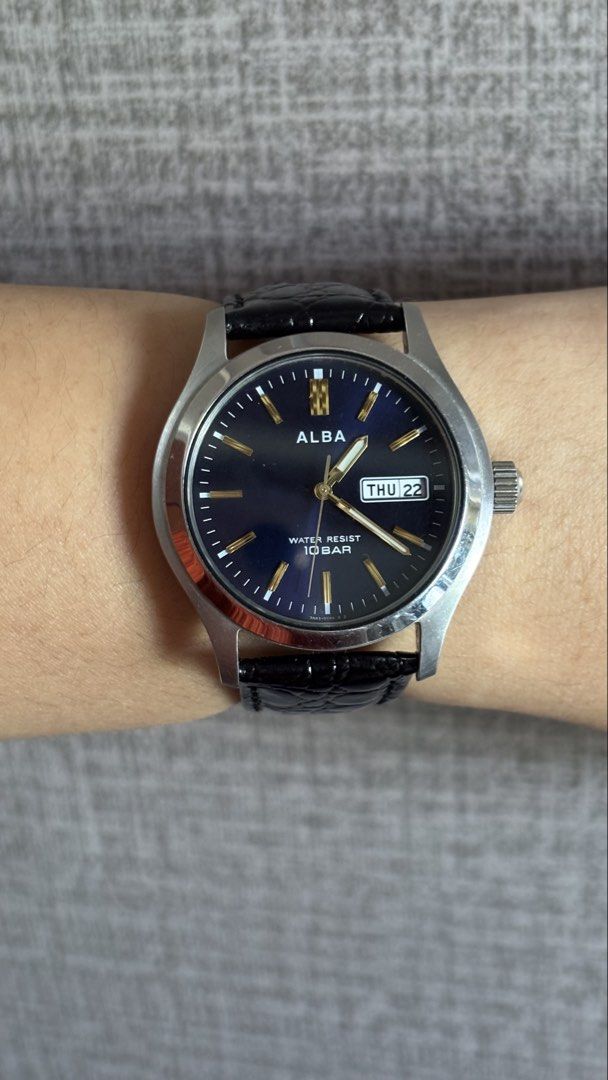 Alba Quartz Blue Dial Day Date Watch (Category: Men's Watches) located in Caloocan City. Submitted by thrift_genieee (Listing ID 1470404955, Image 2). Description: - Brand/Model: Alba Quartz Watch - Dial: Deep blue with gold-tone markers and 3 o'clock day-date window - Case & Strap: Stainless steel case paired with black crocodile-pattern leather strap - Condition: Keeps time accurately, clean look on the wrist, but with noticeable scratches on t