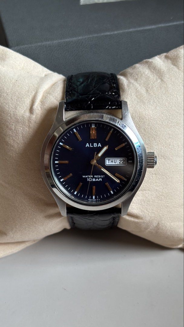 Alba Quartz Blue Dial Day Date Watch (Category: Men's Watches) located in Caloocan City. Submitted by thrift_genieee (Listing ID 1470404955, Image 1). Description: - Brand/Model: Alba Quartz Watch - Dial: Deep blue with gold-tone markers and 3 o'clock day-date window - Case & Strap: Stainless steel case paired with black crocodile-pattern leather strap - Condition: Keeps time accurately, clean look on the wrist, but with noticeable scratches on t