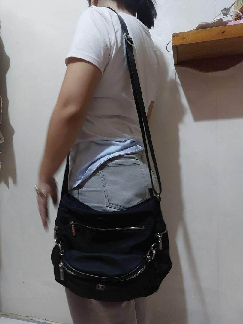 Alberto Black Nylon Crossbody Bag with Multiple Pockets (Category: Cross-body Bags) located in Valenzuela. Submitted by sv072724 (Listing ID 1470475417, Image 3). Description: - Brand: Alberto - Material: Durable black nylon with light beige logo-printed lining - Hardware: Silver-tone, all zippers work smoothly - Strap: Adjustable for comfortable wear - Pockets: Front zipped pocket, curved front pouch, inner zip pocket, and slip compartments - Co