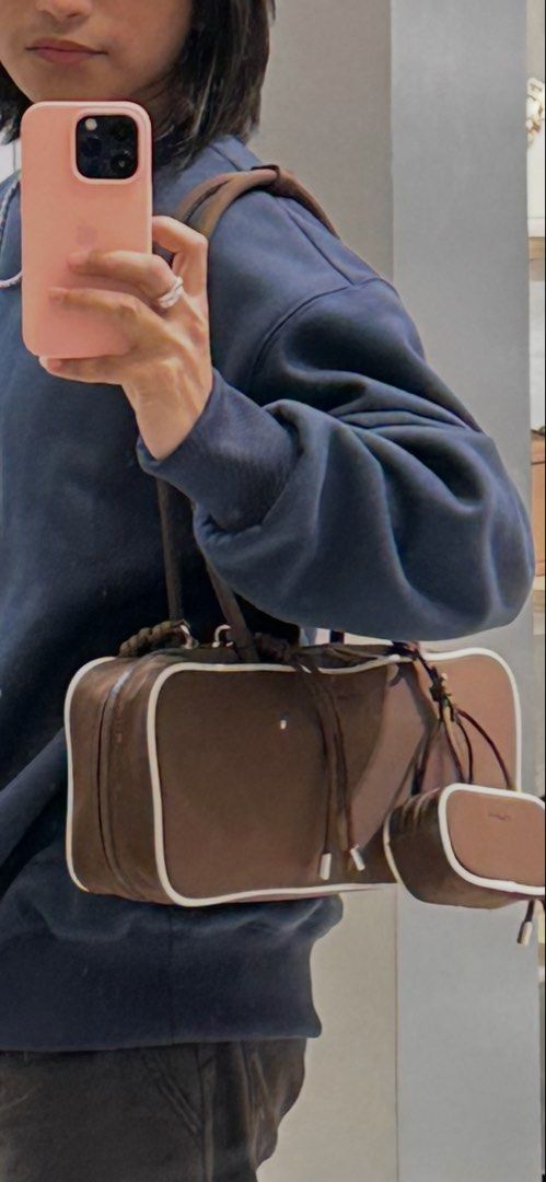 Alberto Bowler bag (brown) (Category: Shoulder Bags) located in Antipolo. Submitted by alparo1999 (Listing ID 1470378047, Image 3). Description: - Brand: Alberto - Material: Smooth, durable nylon-like fabric - Color: Brown with stylish white piping along the edges - Interior: Cream-colored lining featuring the brand's print - Closure: Secure top zipper - Bonus: Includes a matching mini pouch charm attached to the strap - Note: Side keychains show