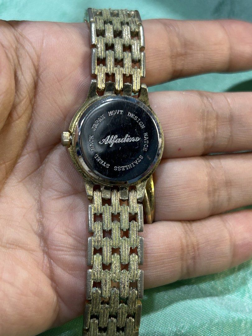 Alfadino Gold Tone Quartz Watch (Category: Women's Watches) located in Cavite. Submitted by mamamia73 (Listing ID 1470530574, Image 3). Description: - Brand/Model: Alfadino vintage quartz watch - Dial: Gold dial with Arabic numerals and a diamond accent at 12 o'clock - Strap: Two-tone textured link bracelet (gold and silver combination) - Back/Movement: Stainless steel back with Japan movement design - Style: Classic vintage timepiece, ideal for 