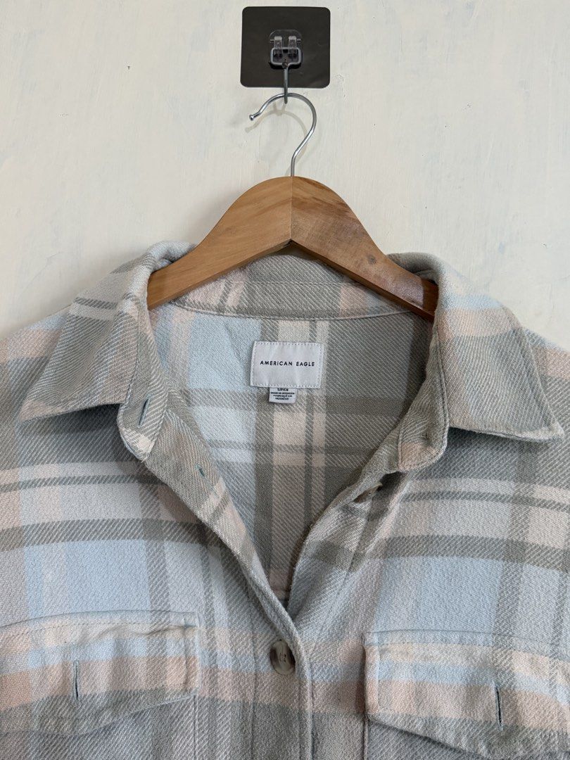 American Eagle Plaid Flannel Button-Up Shirt (Category: Tshirts & Polo Shirts ) located in Manila. Submitted by snipe.shit (Listing ID 1470423614, Image 2). Description: - Brand: American Eagle Outfitters - Style: Plaid flannel button-up shirt - Colorway: Pastel grey, blue, and cream tones - Size: Small - Material: 55% cotton, 45% polyester body with 100% cotton hem - Features: Two chest pockets, front button closure, and curved hem - Condition: 