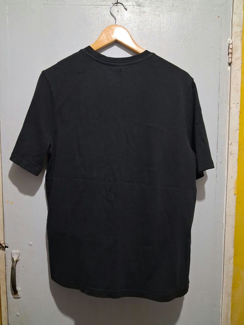 Ami Paris Black Heart Patch T-Shirt (Category: Tshirts & Polo Shirts ) located in General Santos City (Dadiangas). Submitted by nikkomendez31 (Listing ID 1470420226, Image 2). Description: - Brand: Ami Paris - Color: Solid black - Material: Soft, premium cotton - Fit: Regular fit, short sleeves, classic crew neck - Details: Large white heart patch logo on left chest, small embroidered logo lettering on back collar - Condition: Very good.