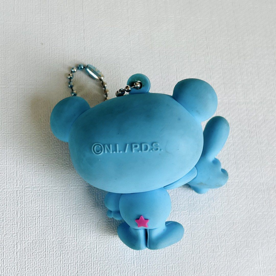 Angel Blue Keychain (Category: Character Goods) located in Cabuyao City. Submitted by nyannyancore (Listing ID 1470363172, Image 2). Description: - Adorable light blue rubber keychain featuring a cute big-eyed cartoon character - Cute pink heart ear details and pink letter A on the chest - Back features copyright text with a small pink star at the bottom - Comes with a sturdy metal ball chain attachment - Compact and lightweight, fits comfortably
