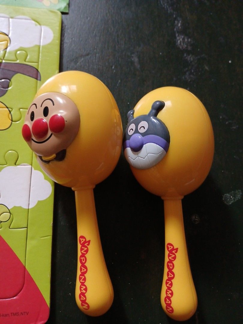 Anpanman Puzzle and Maracas Toy Bundle (Category: Kids Toys) located in Manila. Submitted by diczenestr94951 (Listing ID 1470369941, Image 2). Description: Anpanman themed puzzle featuring various characters on a green background. Includes two yellow maracas, one topped with Anpanman and the other with Baikinman. Good bundle for young children who love the show. Bright colors and fun instruments..