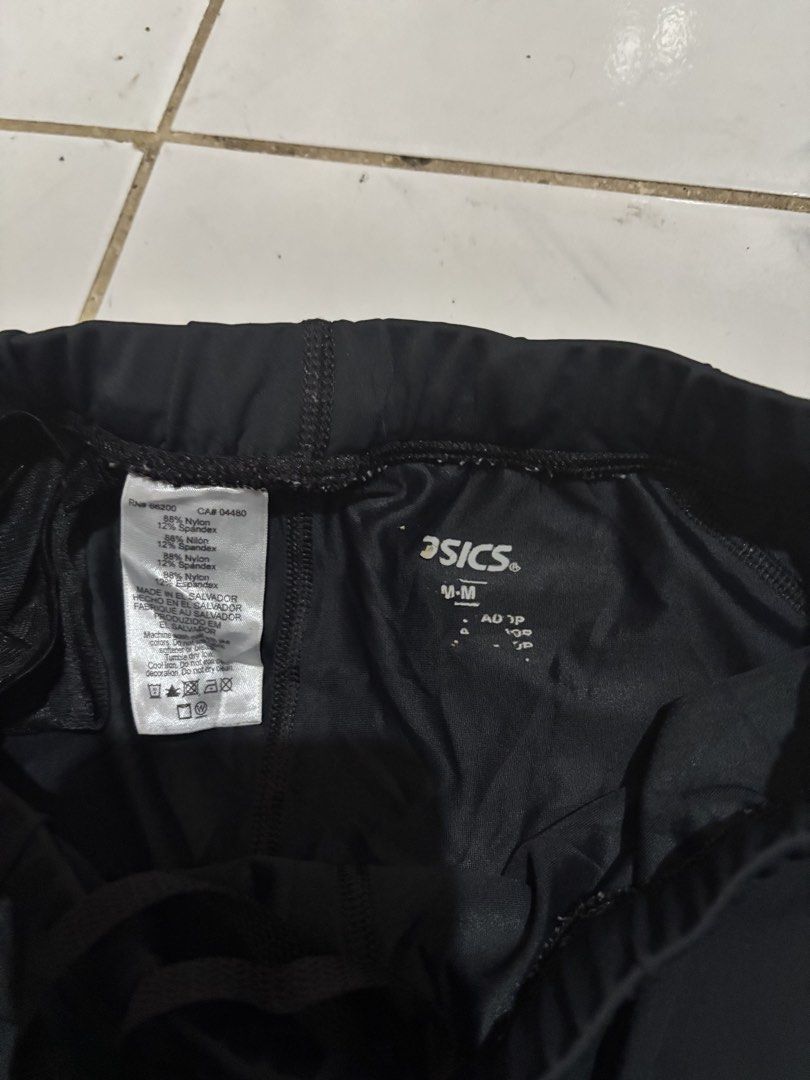 Asics Black Athletic Shorts Size M (Category: Shorts) located in Kalibo. Submitted by mack29 (Listing ID 1470351247, Image 3). Description: - Brand: Asics - Color: Black - Size: Medium (M) - Material: 88% Nylon, 12% Spandex for comfortable stretch - Waistband: Elastic with adjustable drawstring - Details: Silver Asics logo printed near the front and back hem - Condition: Clean interior tags with material and care instructions.