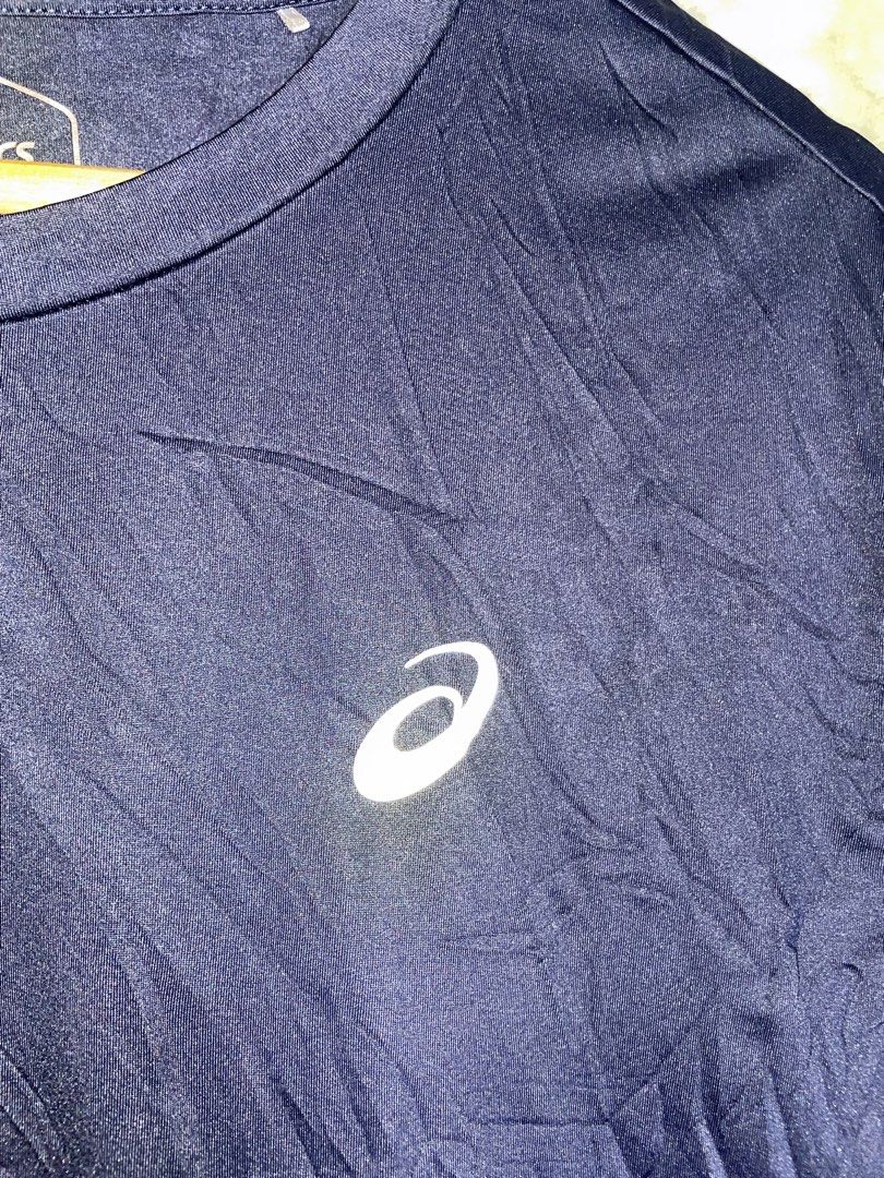 Asics Navy Blue Athletic T-Shirt Size L (Category: Activewear) located in Molave. Submitted by charlesthrifter (Listing ID 1470358439, Image 2). Description: - Brand: Asics - Color: Navy blue with white logo on chest - Size: L - Material: Polyester blend - Design: Short sleeves, crew neck - Origin: Made in Indonesia - Condition: Excellent, ready to wear.