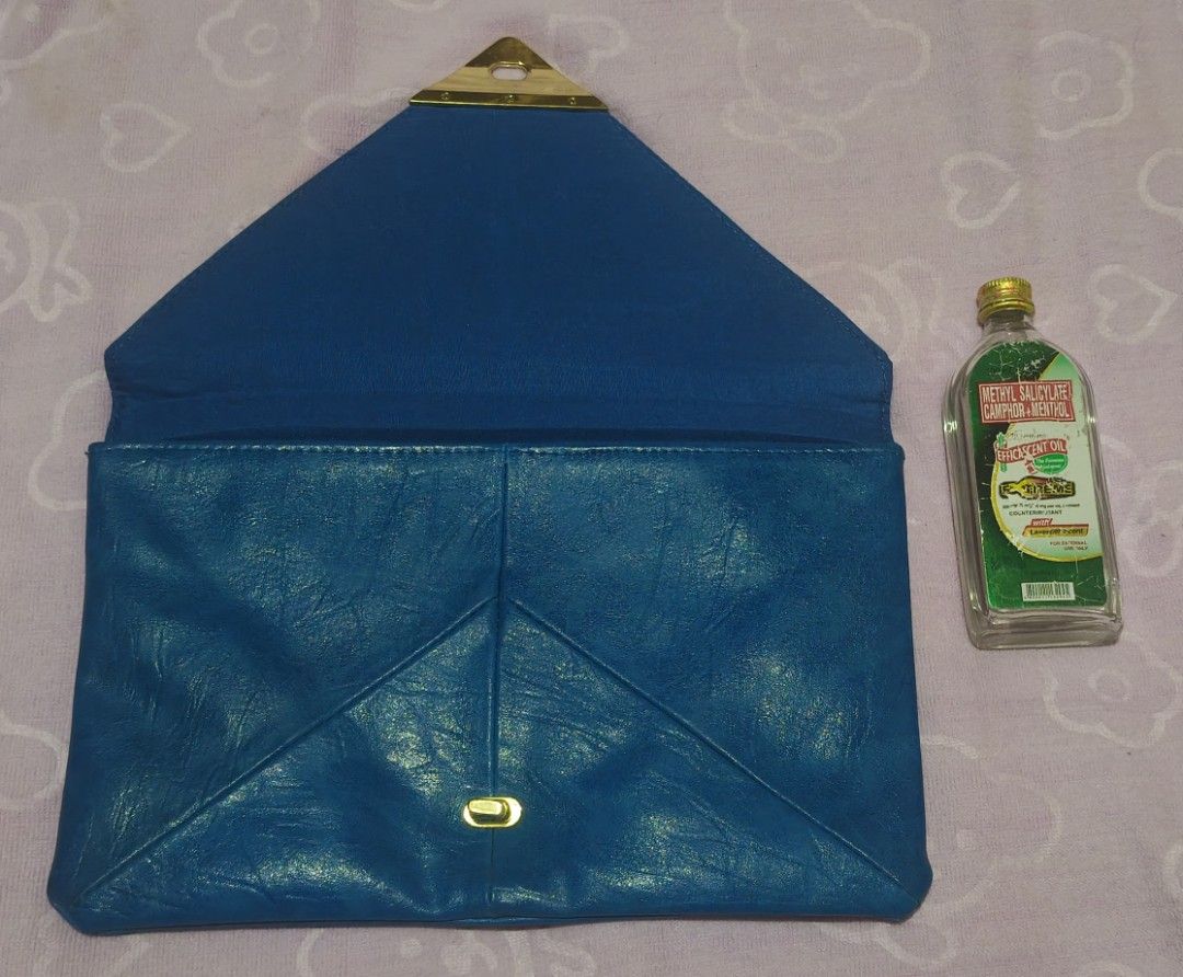 Vintage ASOS Pyramid Lock Envelope Clutch (Category: Clutches) located in Villasis. Submitted by bunnybabe08 (Listing ID 1470484464, Image 2). Description: • Brand: ASOS • Material: Faux Leather / Vinyl • Color/Hardware: Cobalt Blue / Gold-Tone • Condition: Structural envelope design with geometric flap. Distinct triangular turn-lock closure mechanism works perfectly. Clean interior lining. Minor superficial hairline scratches on the gold hardwar