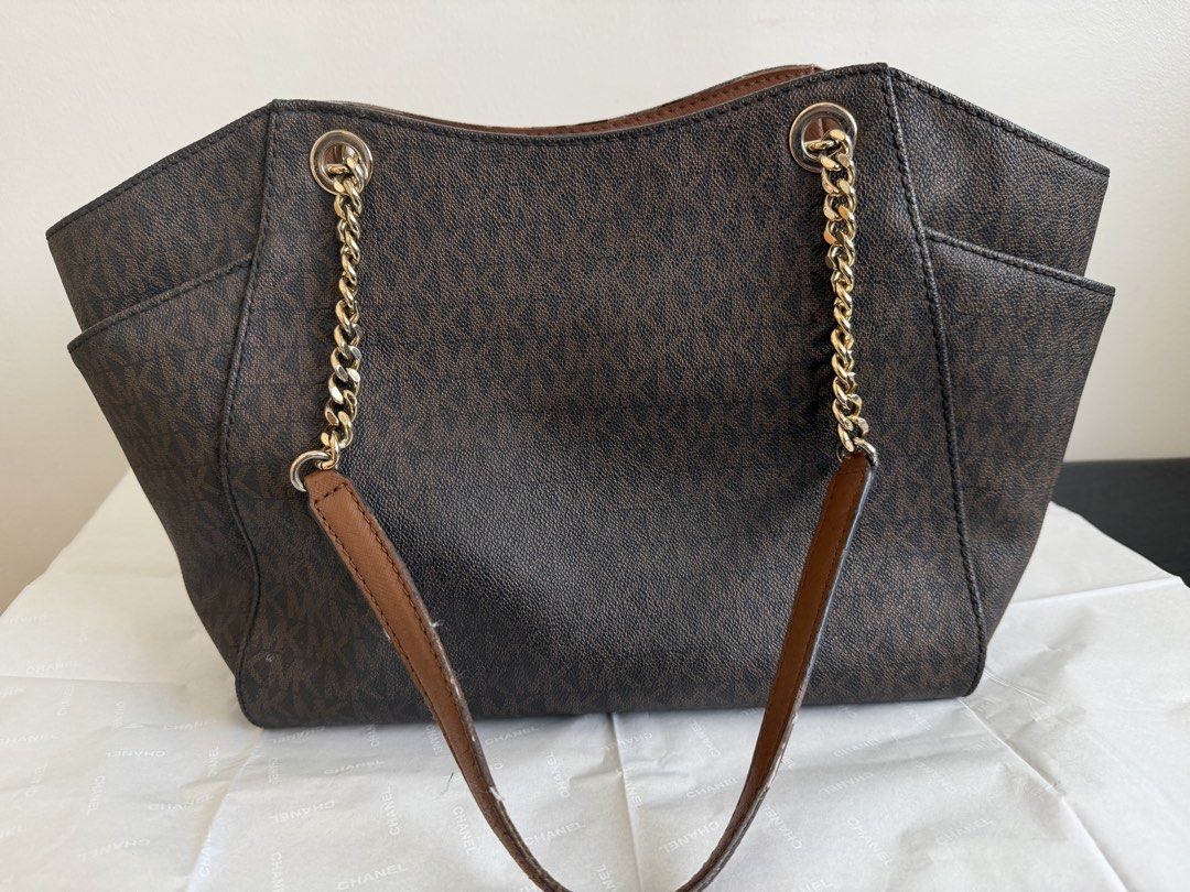 Authentic Michael Kors Jet Set Large Chain Shoulder Tote (Category: Luxury Bags & Wallets) located in Makati City. Submitted by fashio-anne (Listing ID 1470403573, Image 3). Description: Michael Kors Jet Large Chain Shoulder Tote in the classic “Brown/Luggage” color combination • Material: Crafted from dark brown MK signature logo-print coated canvas with acorn-brown leather trim. • Handles: Features dual leather top handles accented with elegant