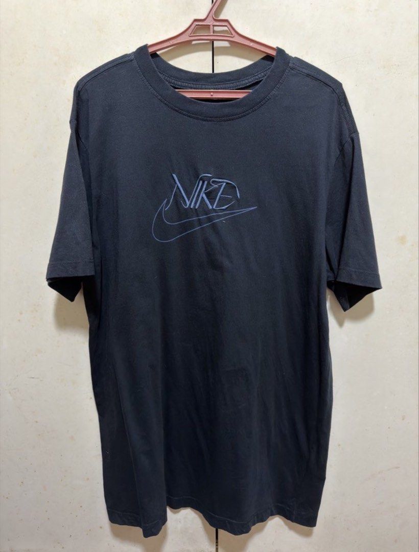 Authentic Nike T-Shirt with Embroidered Logo (Category: Shirts) located in Taytay. Submitted by melaniemaep (Listing ID 1470389543, Image 1). Description: - Brand: Nike - Color: Dark blue with stylized blue embroidered chest logo - Material: Comfortable cotton fabric - Size/Measurements: Measured flat approx. 29" length x 20" chest - Style: Casual short sleeve crewneck, perfect everyday streetwear - Versatility: Easy to style with denim jeans or 
