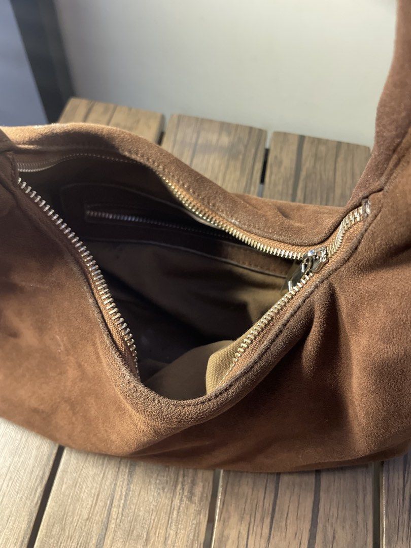AZTRD Brown Suede Shoulder Bag (Category: Shoulder Bags) located in Antipolo. Submitted by declutterandthrifts (Listing ID 1470432216, Image 2). Description: - Brand: AZTRD - Material: Soft brown suede with dark fabric lining - Closure: Secure top zipper - Storage: Spacious main compartment with an extra interior zipped pocket - Details: Minimal silver logo hardware on the front - Style: Classic hobo shape, perfect for daily essentials -Small use