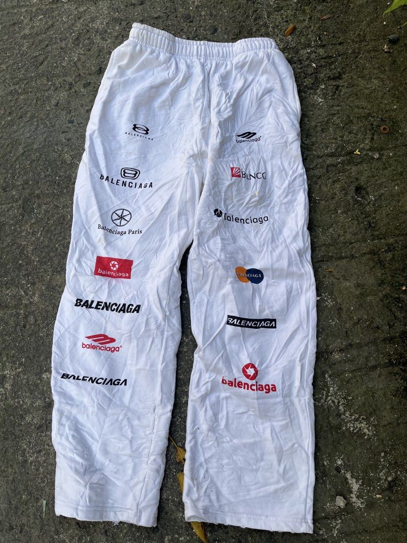 Balenciaga Multi Logo Printed Sweatpants White Size L (Category: Joggers) located in Manila. Submitted by shanaaa.collects (Listing ID 1470394929, Image 1). Description: - Brand: Balenciaga - Color: White - Material: Heavy cotton fleece - Design: All-over brand logo prints on legs - Details: Elastic waistband with adjustable drawstring - Origin: Made in Portugal - Size: L (tag attached) - Condition: Shows some light stains from wear - Style: Perf