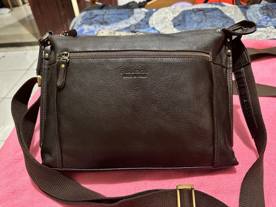 Bally Dark Brown Leather Crossbody Bag (Category: Luxury Bags & Wallets) located in Quezon City. Submitted by pongoy (Listing ID 1470392755, Image 2). Description: - Brand: Bally - Origin: Made in Italy - Material: Premium dark brown grained leather with silver-tone hardware - Strap: Adjustable canvas strap - Storage: Deep main compartment and convenient front zippered pocket - Condition: Clean interior, excellent structure, durable for everyday 