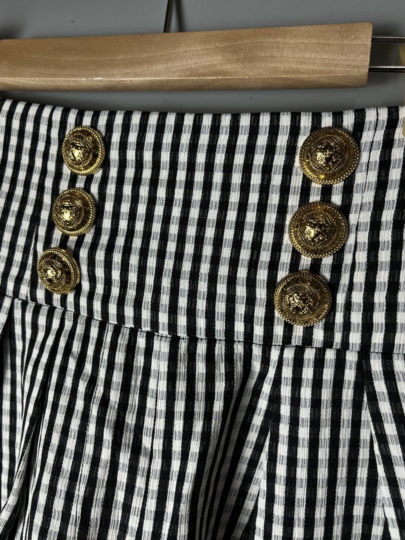 Balmain Black and White Gingham High-Waisted Shorts (Category: Shorts) located in Dagupan City. Submitted by loves2thrifth (Listing ID 1470420100, Image 3). Description: - Brand: Balmain - Pattern: Black and white gingham - Fit: High-waist with structured pleats and cuffed hems - Details: Double-breasted gold embossed front buttons and exposed gold-tone back zipper with branded pull tab - Condition: Clean fabric, crisp pattern - Environment: From