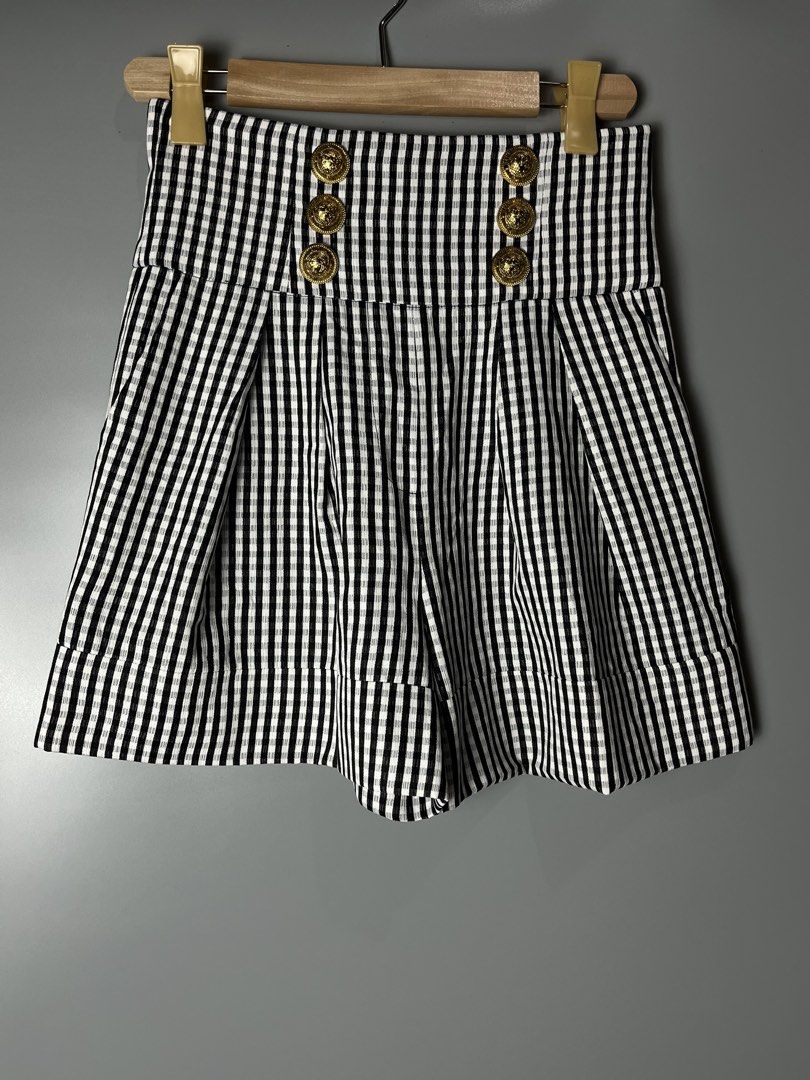 Balmain Black and White Gingham High-Waisted Shorts (Category: Shorts) located in Dagupan City. Submitted by loves2thrifth (Listing ID 1470420100, Image 1). Description: - Brand: Balmain - Pattern: Black and white gingham - Fit: High-waist with structured pleats and cuffed hems - Details: Double-breasted gold embossed front buttons and exposed gold-tone back zipper with branded pull tab - Condition: Clean fabric, crisp pattern - Environment: From