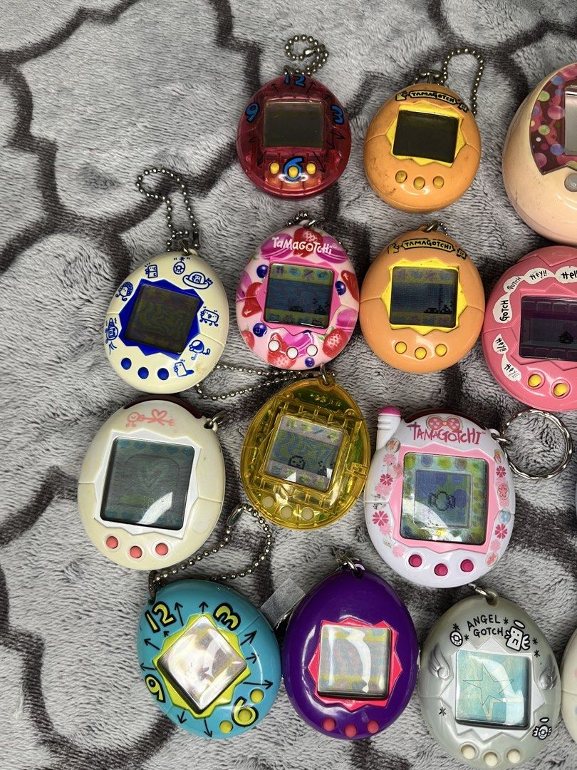 Bandai Tamagotchi Virtual Pet Collection (Category: Interactive Toys) located in Caloocan City. Submitted by snapshop_ph (Listing ID 1470403108, Image 2). Description: - Classic Tamagotchi virtual pets available for individual sale or bundles - Assorted rare shell designs: clock face, strawberry, yellow translucent, purple, angel, and swirl patterns - Fully working units with digital pixel screens and character icons - Includes attached keychains