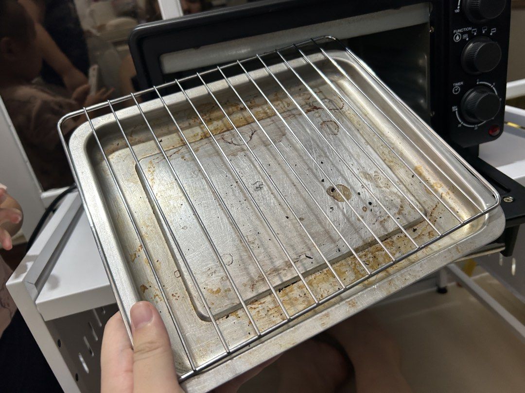 Baumann Living Oven Toaster (Category: Ovens & Toasters) located in Cavite. Submitted by am0602 (Listing ID 1470351339, Image 3). Description: Black Baumann Living toaster oven with stainless steel handle. Temperature knob goes up to 230 degrees Celsius. Function selector and timer dial up to 30 minutes. Includes wire rack and baking tray. Interior and tray show some food stains and grease marks from previous cooking sessions. Glass door with cle