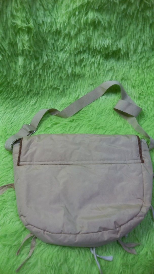 Beige Shoulder Bag with Floral Patch and Drawstrings (Category: Shoulder Bags) located in Manila. Submitted by twinklelyn03 (Listing ID 1470409285, Image 2). Description: - Material: Durable beige nylon fabric - Design: Front flap with floral embroidery, fabric patch, and white tie-string details - Interior: Smooth fabric lining with a handy inner slip pocket - Closure: Secure velcro front closure - Strap: Adjustable shoulder strap for comfortabl