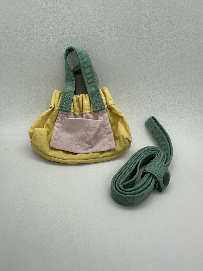Beyond the Vines Teeny Tiny Micro Dumpling - Yellow Colorblock (Category: Cross-body Bags) located in Quezon City. Submitted by afpar (Listing ID 1470497454, Image 1). Description: - Brand: Beyond The Vines - Style: Micro Dumpling Bag - Colorway: Yellow body with green handles and pink front pocket - Included: Detachable matching green crossbody strap - Features: Ruffled top edge and embroidered brand text on the front pocket - Condition: Brand n