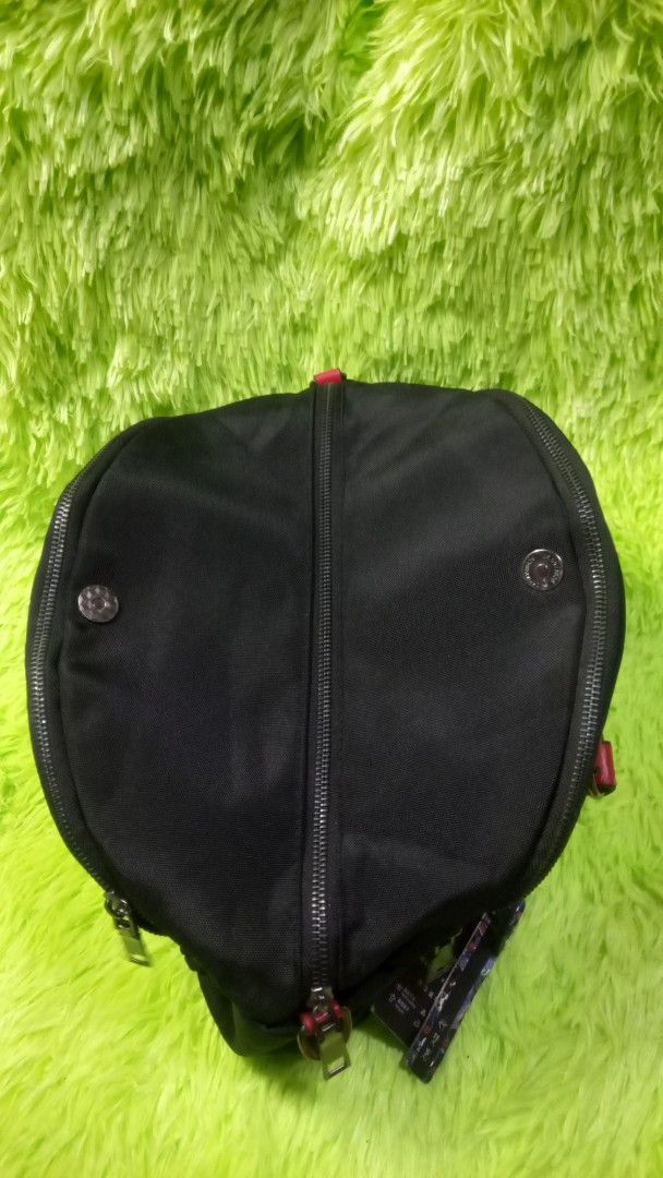 Black and Red Handbag with Round Logo (Category: Tote Bags) located in Manila. Submitted by twinklelyn03 (Listing ID 1470412873, Image 3). Description: - Color: Black canvas with bold red handles and red round logo patch - Storage: Main compartment with zipper and snap button ends, plus a convenient outer back zip pocket - Strap: Includes a detachable long shoulder strap (tucked inside) - Condition Note: Has a small tear on the red handle near th