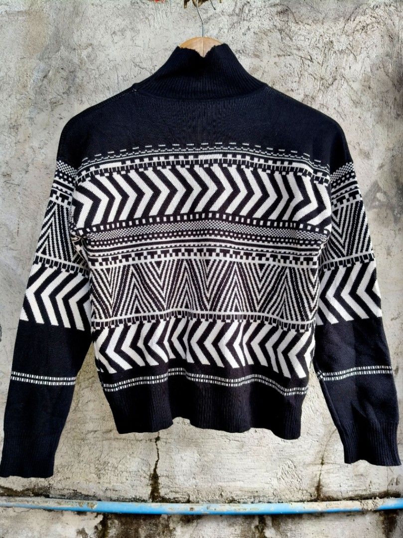 Black and White Geometric Pattern Turtleneck Sweater (Category: Longsleeves) located in Makati City. Submitted by thriftersmakati (Listing ID 1470385806, Image 1). Description: - Color: Black and white - Design: Bold geometric chevron and tribal-inspired patterns across chest and sleeves - Neckline: High folded collar / turtleneck style - Sleeves & Hem: Long sleeves with ribbed cuffs and hem - Material: Cozy knit fabric - Condition: Excellent.