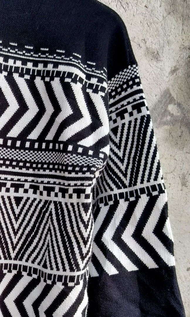 Black and White Geometric Pattern Turtleneck Sweater (Category: Longsleeves) located in Makati City. Submitted by thriftersmakati (Listing ID 1470385806, Image 2). Description: - Color: Black and white - Design: Bold geometric chevron and tribal-inspired patterns across chest and sleeves - Neckline: High folded collar / turtleneck style - Sleeves & Hem: Long sleeves with ribbed cuffs and hem - Material: Cozy knit fabric - Condition: Excellent.
