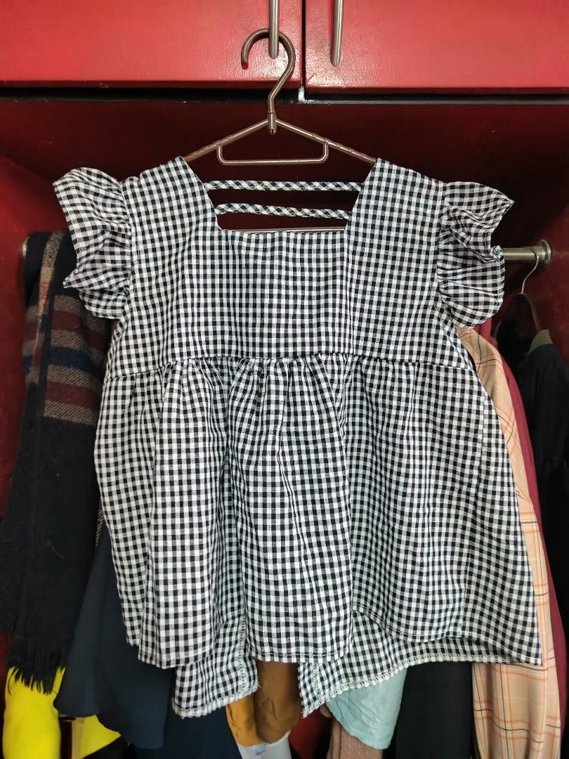 Black and white gingham ruffled blouse with button front (Category: Blouses) located in Caloocan City. Submitted by MovesLikeJeager (Listing ID 1470388637, Image 2). Description: - Pattern: Classic black & white checkered gingham - Design: Flutter sleeves with ruffles, square neckline, and slight peplum waist - Closure: Button-down front with dark buttons - Fabric: Lightweight and breathable, perfect for warm weather or layering - Styling: Versat